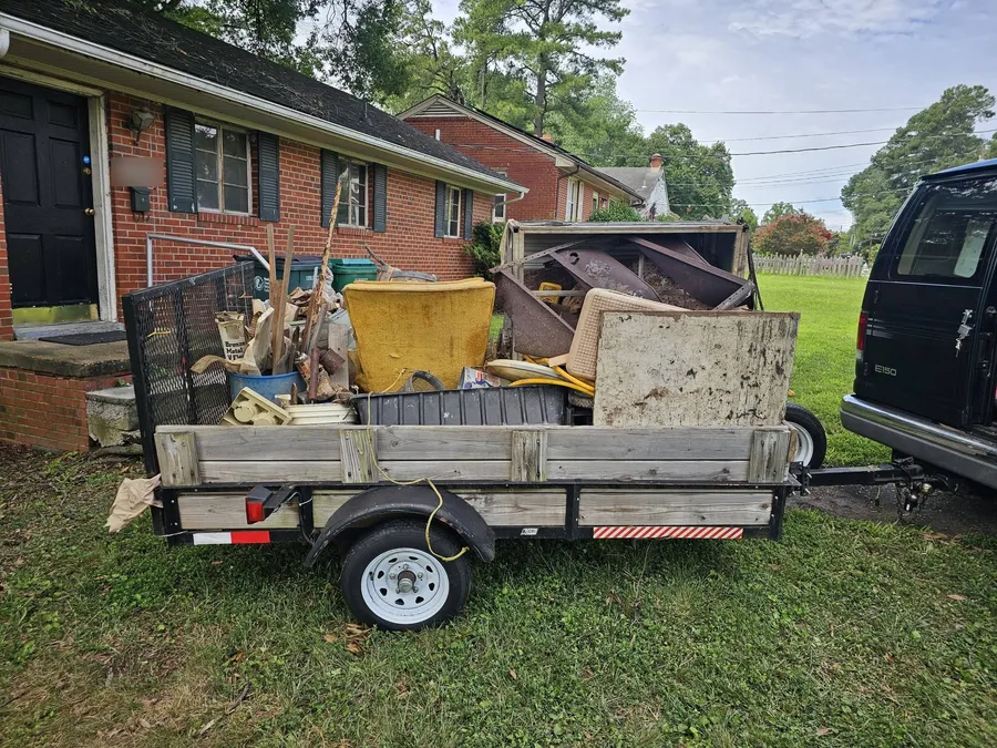 Our trailer loaded with junk in front of a brick Richmond house